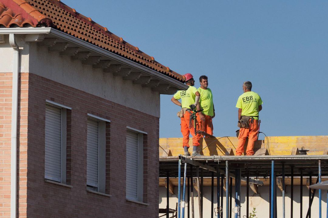 Unos trabajadores durante su jornada laboral en un edificio en construcción