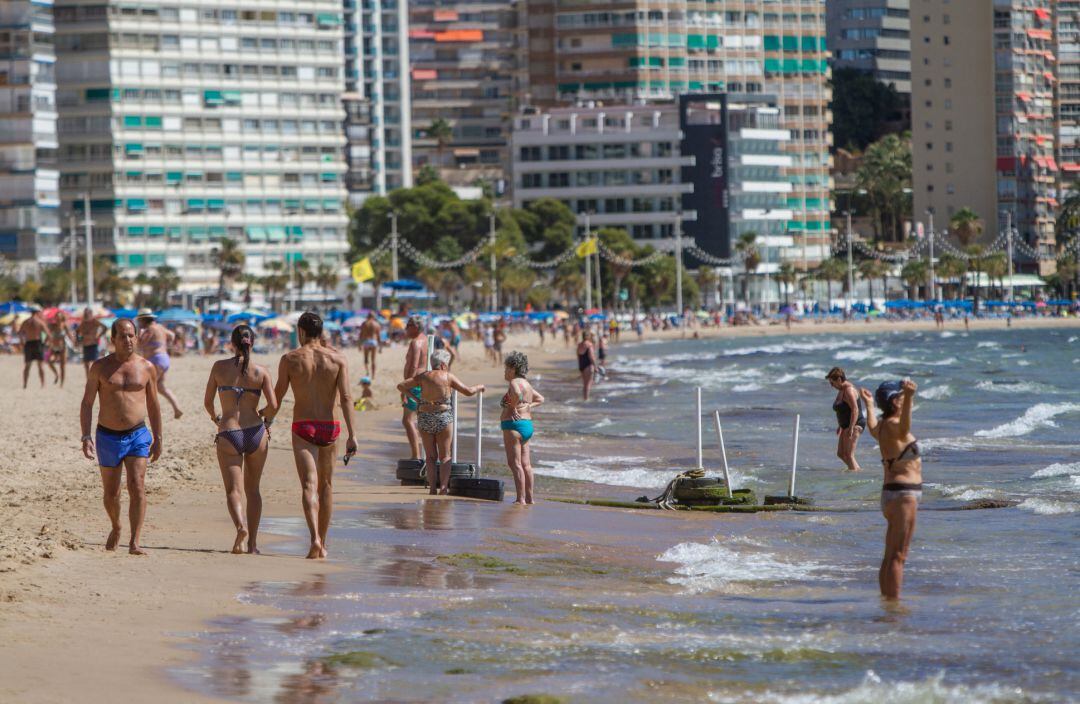 Varias personas pasean por la Playa de Levante de Benidorm en una foto de archivo.