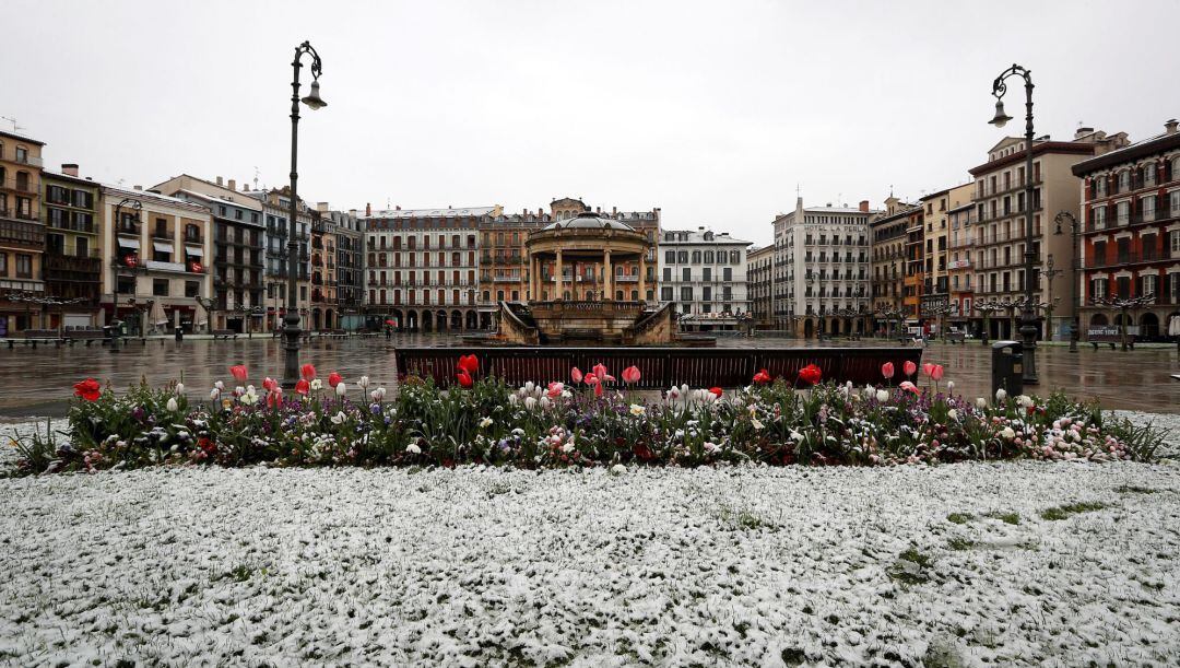 La nieve ha regresado este martes a Pamplona, llegando a cuajar desde primeras horas de la mañana en algunas zonas, si bien por ahora no se registran incidencias reseñables. En la imagen, la Plaza del Castillo de la capital navarra. 