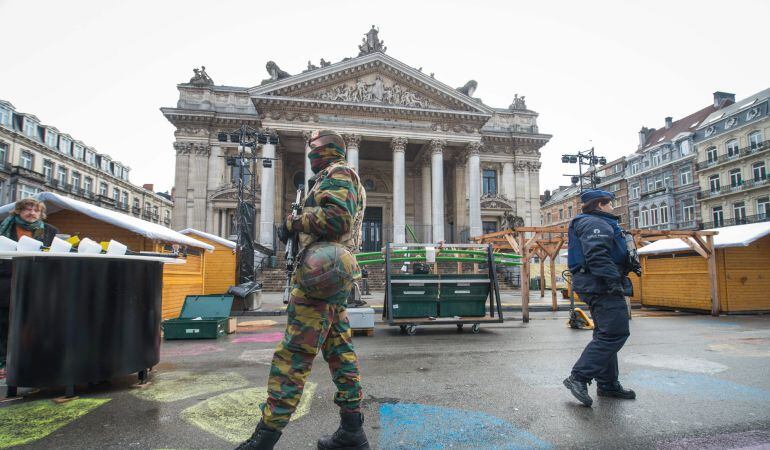 Un oficial de policía y un soldado patrullan frente de la Bolsa de Bruselas.