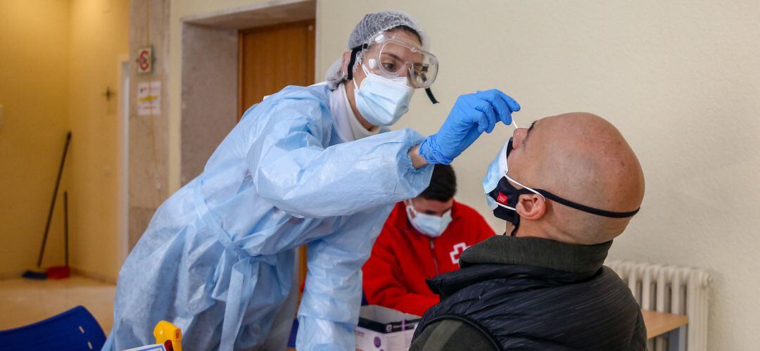 Una sanitaria realiza un test de antígenos a un hombre en un dispositivo organizado por la Comunidad de Madrid