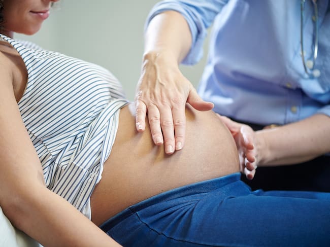 Una mujer embarazada es examinada por una matrona