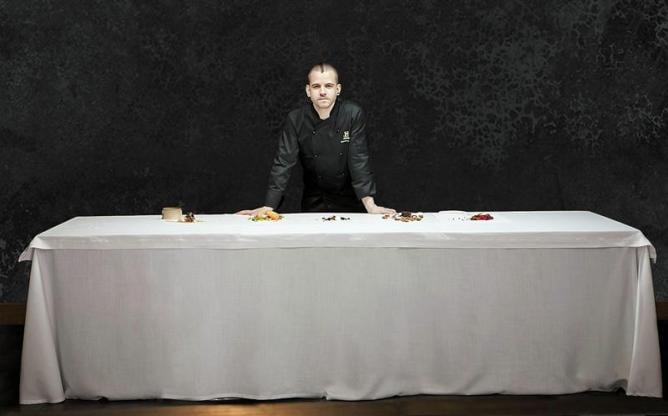 Fotografía facilitada por Canal Historia del cocinero David Muñoz junto a los platos que conforman su reinterpretación de la Última Cena de Jesús y los Apóstoles y cuya realización será emitida por el canal de televisión este viiernes, 22 de marzo.