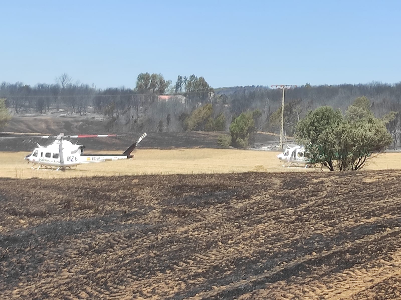 Dos de los helicópteros de la UME tomando tierra cerca del Puesto de Mando Avanzado del operativo contra el incendio, entre las localidades de Santo Domingo de Silos y Santibáñez del Val. / Foto: Radio Castilla