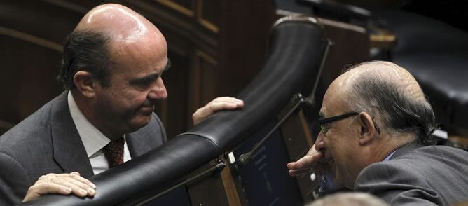 El ministro de Economía, Luis de Guindos, conversa con el ministro de Hacienda, Cristóbal Montoro, en el Congreso