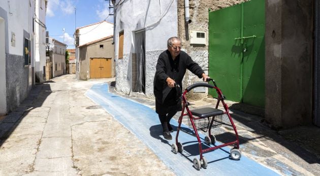 Tía Rosa, de 86 años, camina con el andador por el carril habilitado para ello en Pescueza (Cáceres).