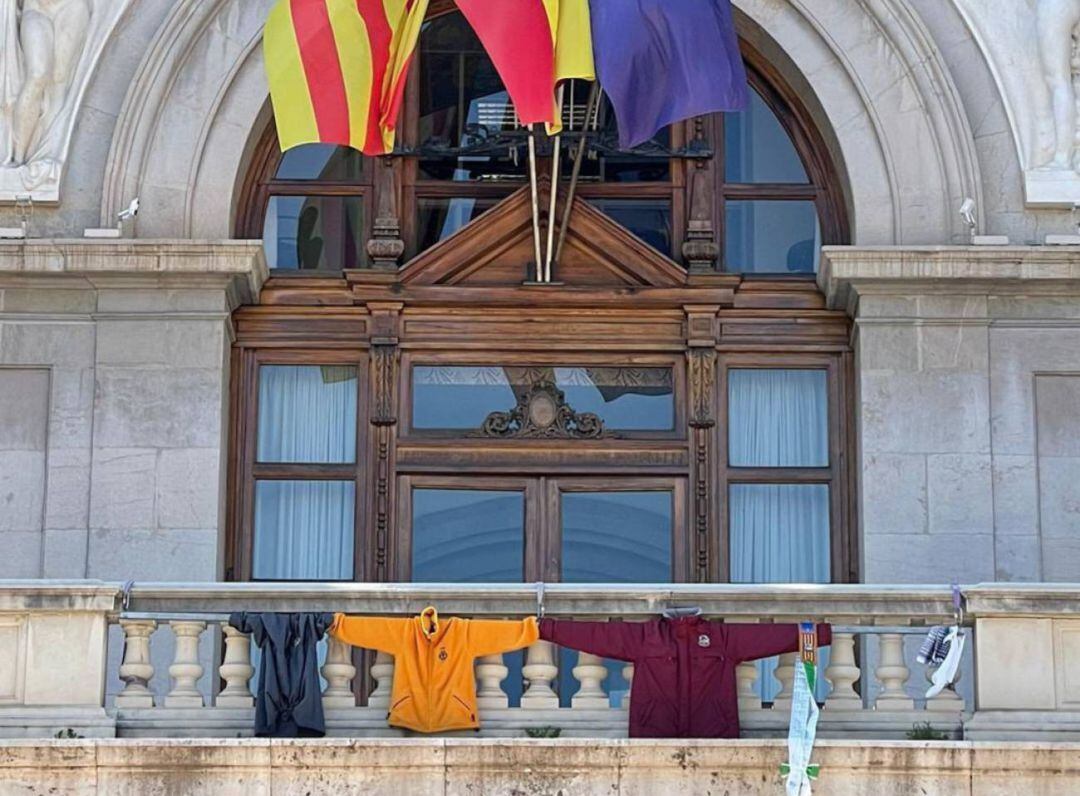 Ropa fallera colgada del balcón del Ayuntamiento de València en homenaje a las Fallas suspendidas por el coronavirus