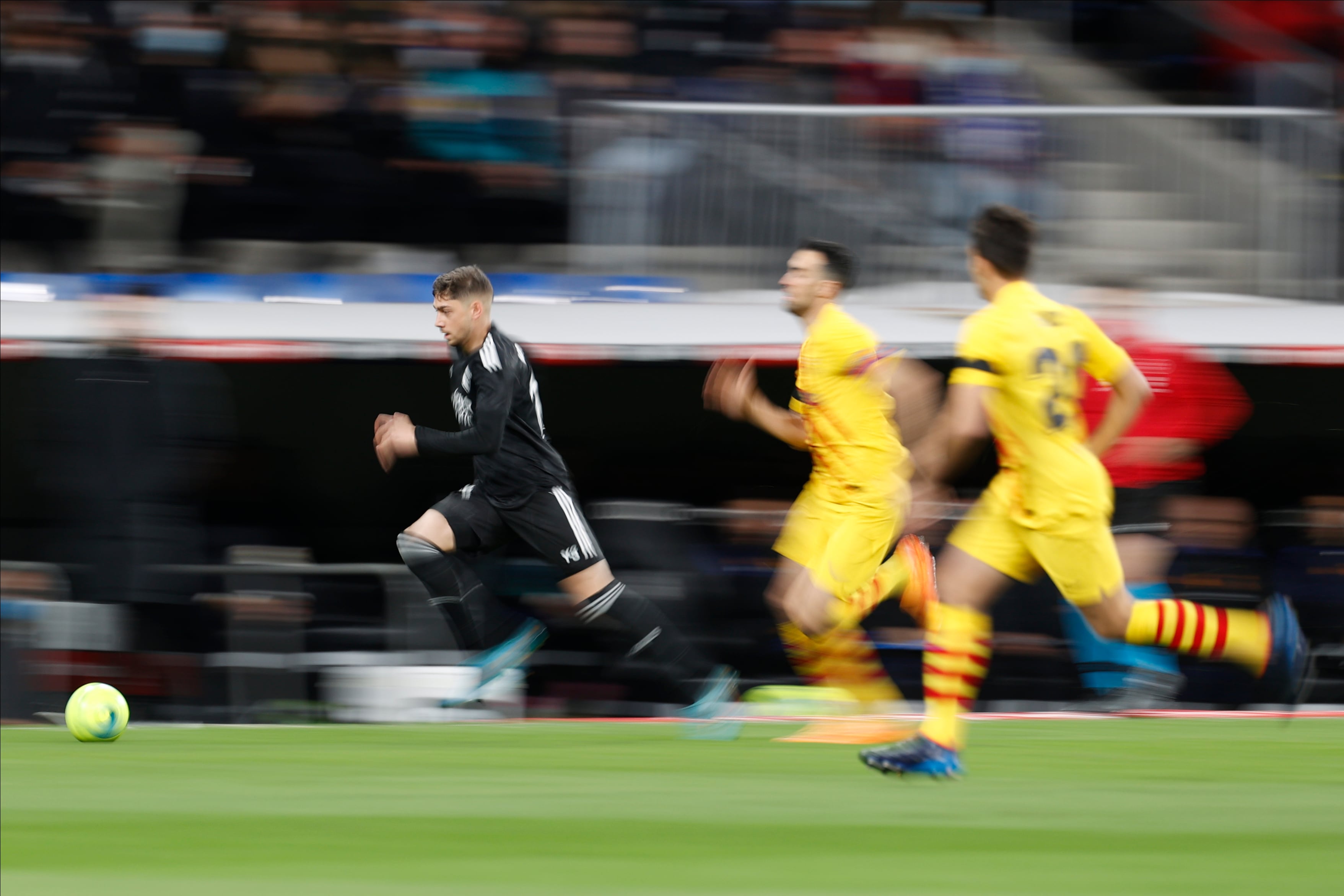 El centrocampista uruguayo del Real Madrid, Fede Valverde, conduce el balón ante el centrocampista del FC Barcelona, Sergio Busquets