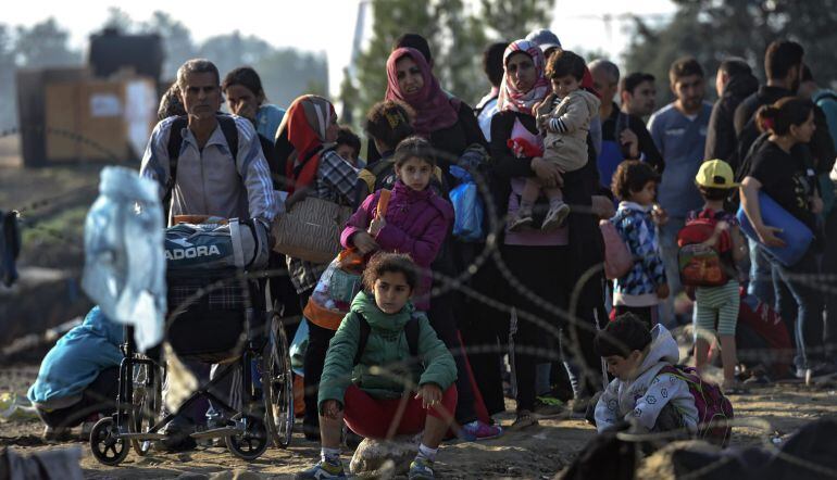 Refugiados esperan para recibir el permiso y poder cruzar la frontera entre Grecia y Macedonia, cerca de la ciudad de Gevgelija (Macedonia). EFE/Georgi Licovski