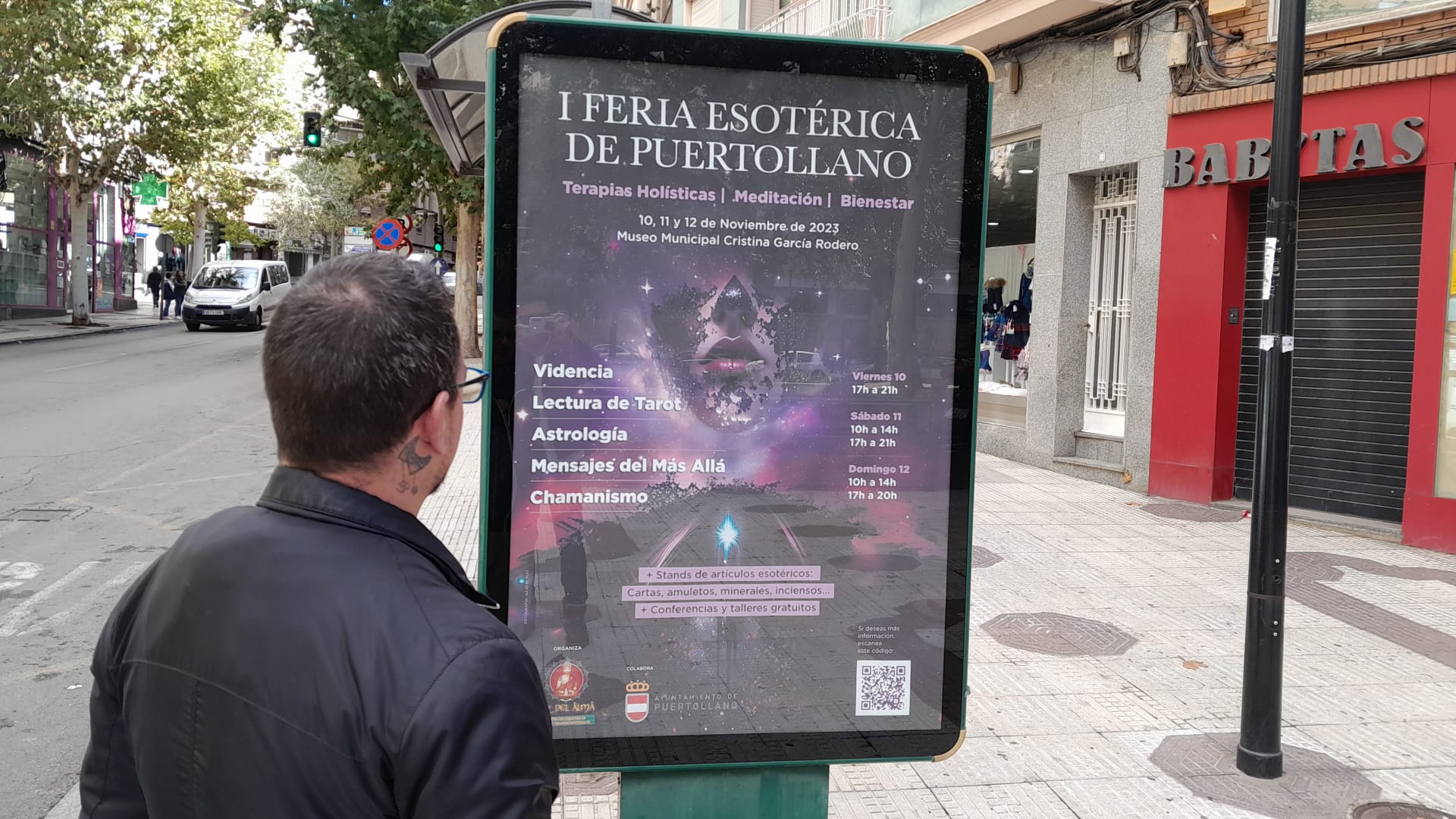 Un ciudadano contempla un mupi promocional de la Feria