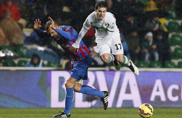 GRA328. ELCHE (ALICANTE), 18/01/2015.- El centrocampista del Elche, Victor Rodriguez (d), cae ante la entrada del defensa del Levante, Juanfran, durante el encuentro correspondiente a la decimonovena jornada de primera división, que han disputado esta noc