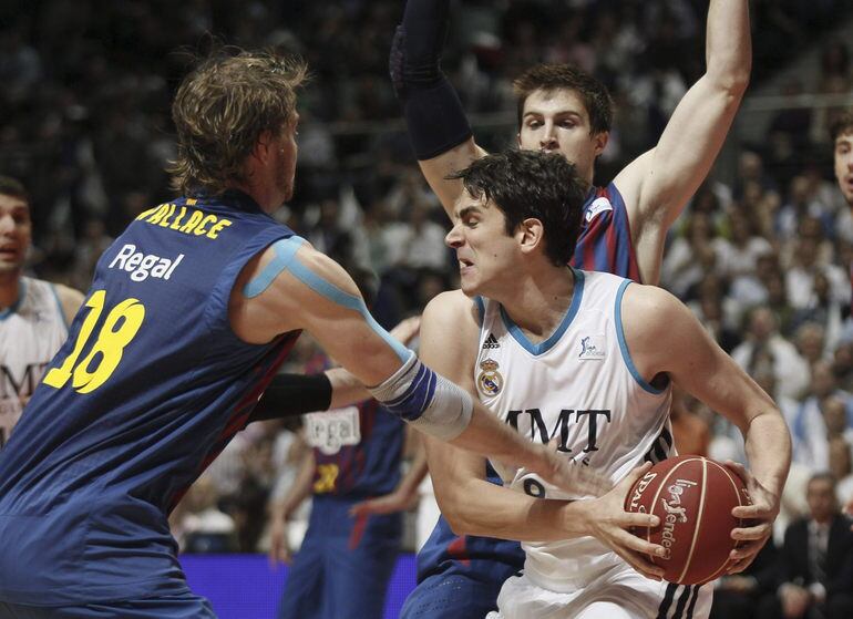 Carlos Suarez lucha con el ala pivot norteamericano del Barcelona Regal, C.J. Wallace, durante el primer partido de la final de la Liga Endesa de Baloncesto disputado en el Palacio de los Deportes de la capital