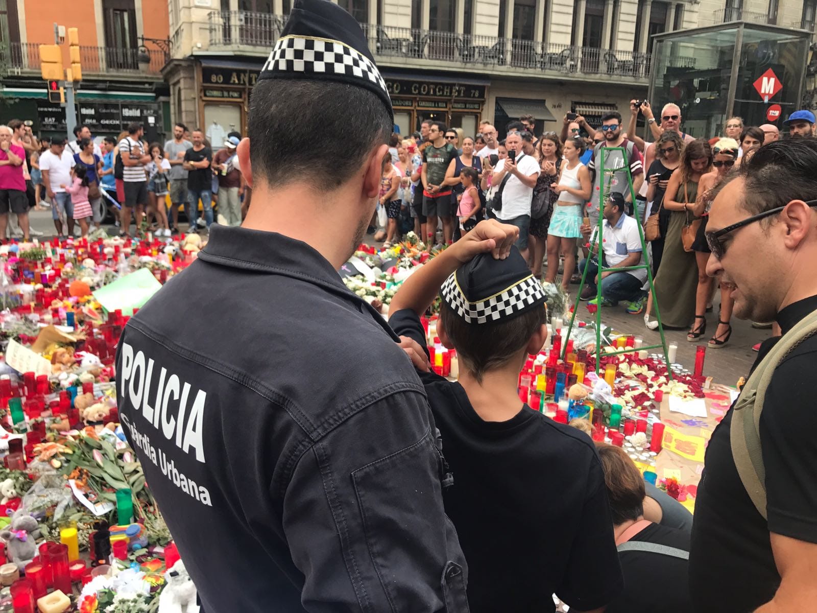 Un supervivent del 17A amb un policia de la ciutat de Barcelona davant l&#039;ofrena a les víctimes dels atemptats.