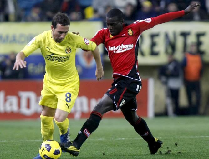 El centrocampista del Villarreal Santiago Cazorla pelea un balón con el centrocampista francés del Real Mallorca, Michael Pereira, en su partido correspondiente a la decimosexta jornada de Liga en Primera División