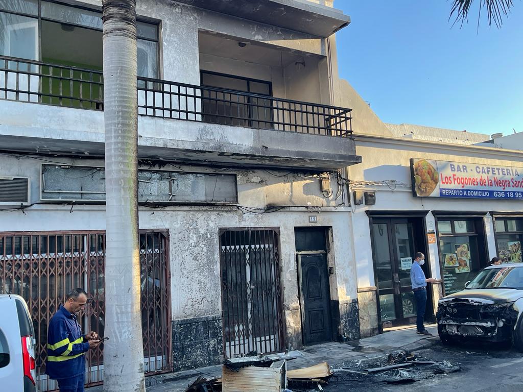 La vivienda junto a uno de los coches afectados.