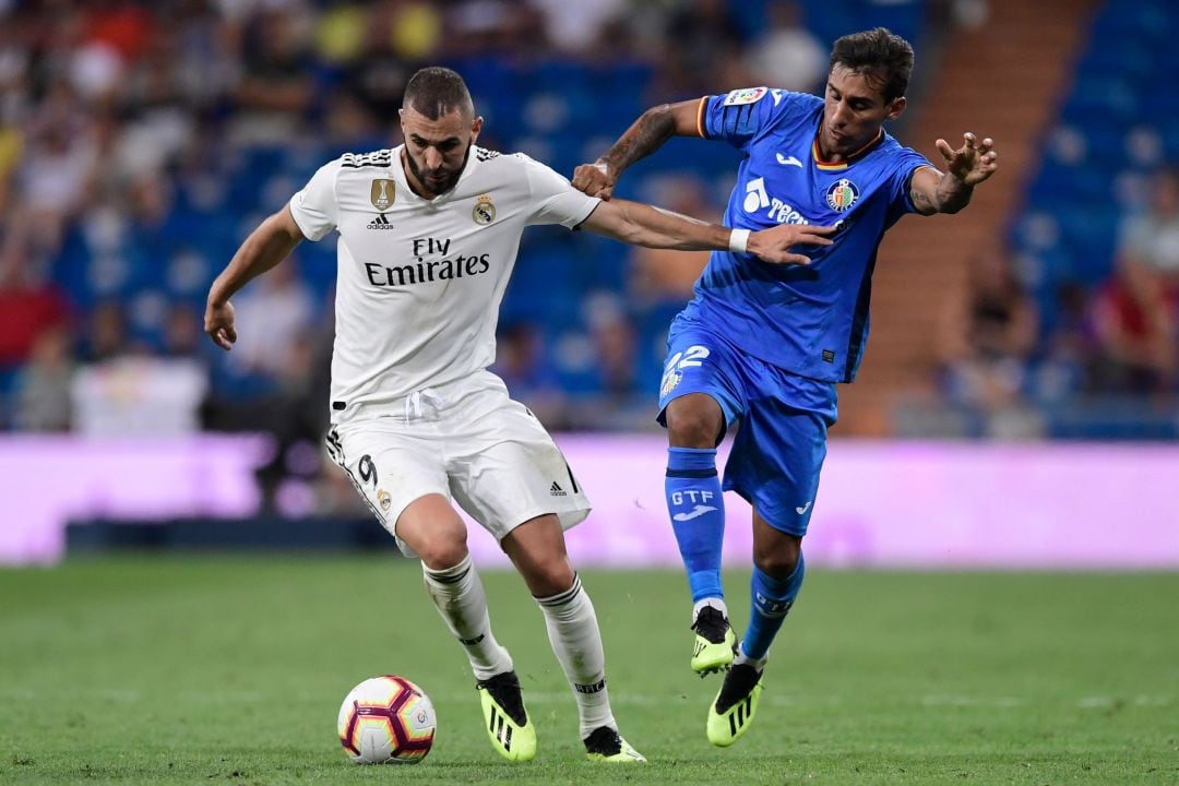 Karim Benzema pugna por el esférico con Damián Suárez durante el encuentro entre el Real Madrid y el Getafe CF disputado en el Santiago Bernabéu