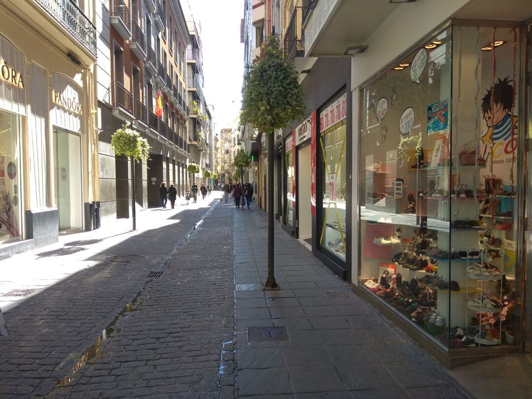 La calle Mesones, en pleno centro de Granada, con muy pocos viandantes y algunos comercios cerrados en pleno cierre perimetral del municipio como medida anti-covid