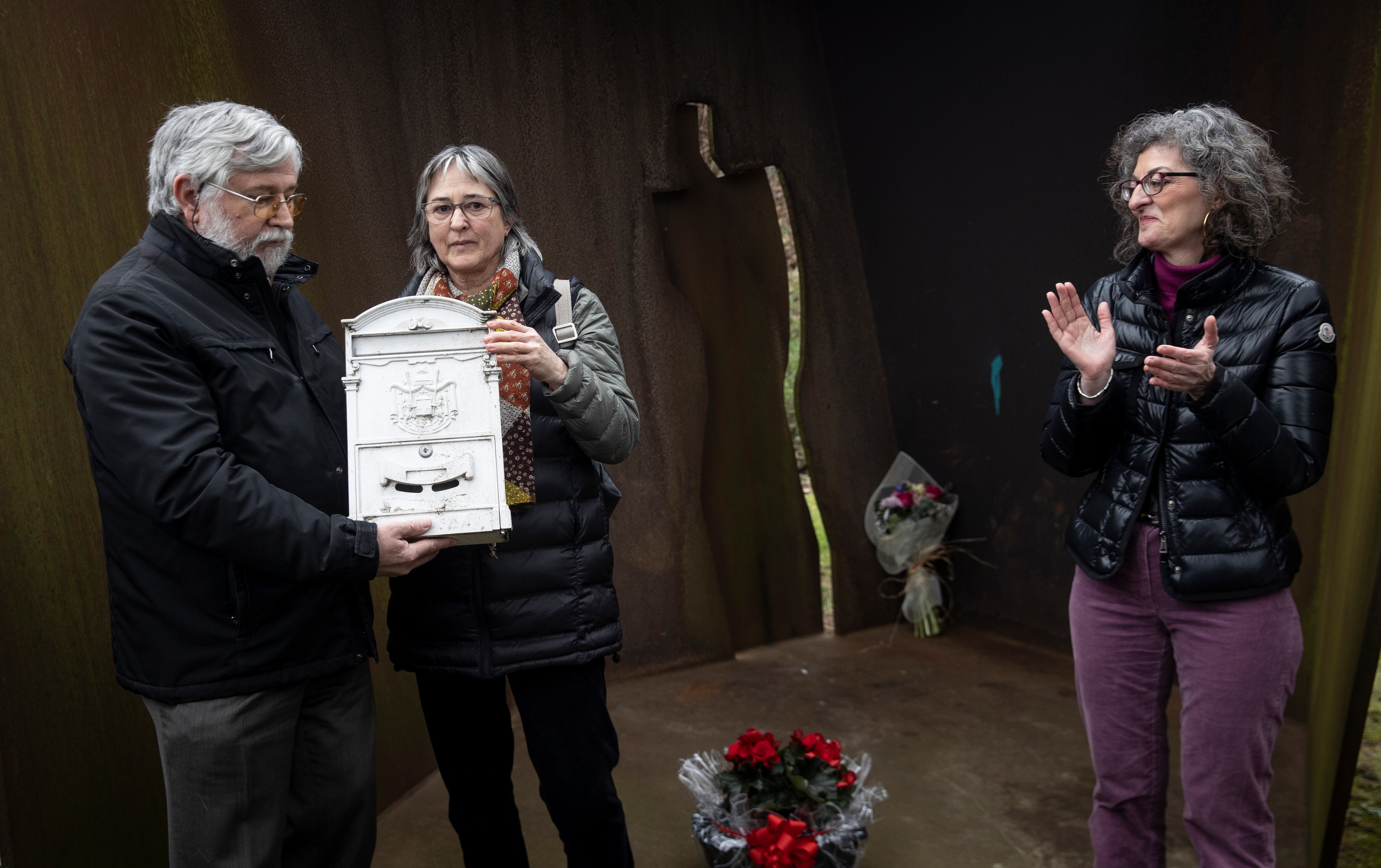 La viuda de Joseba Pagazaurtundua, Estíbaliz Garmendia (c), y su hermana, Maite Pagazaurtundua (d), reciben el buzón que ha estado colocado en la escultura en honor al exjefe de la policía local de Andoain asesinado por ETA hace 20 años de manos del director de Memorial de la Víctimas del Terrorismo, Florencio Domínguez, durante un acto de recuerdo celebrado este domingo en Andoain (Gipuzkoa). EFE/ Javier Etxezarreta