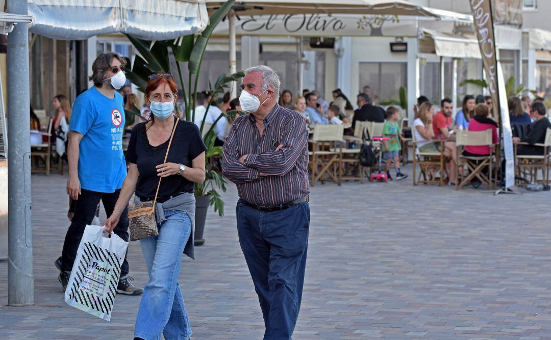 Varias personas pasean con la mascarilla puesta.