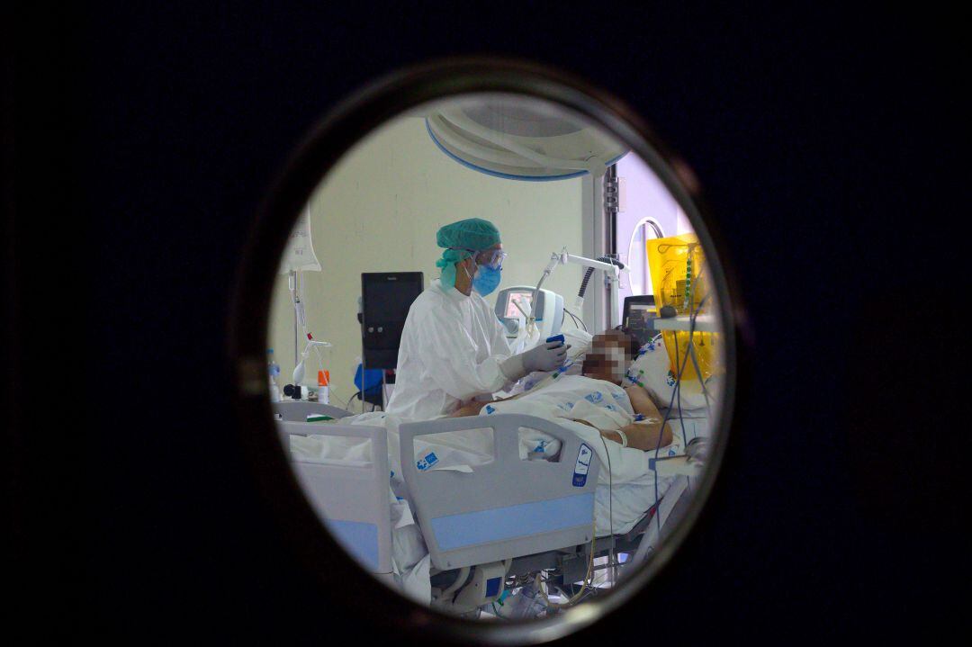 Personal sanitario atendiendo a un paciente de COVID-19 en la UCI. 