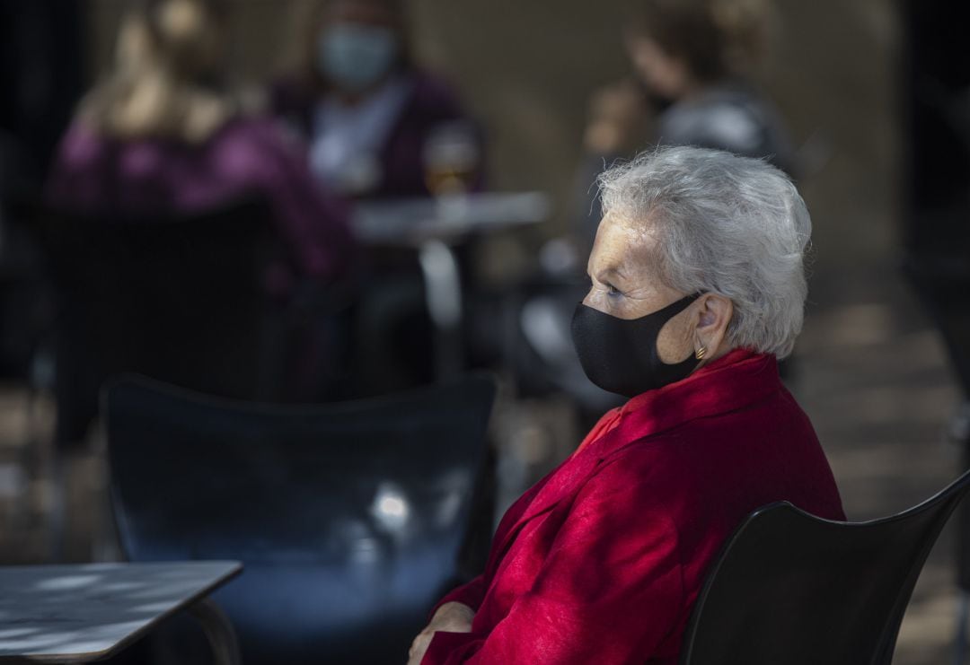 Una mujer mayor con mascarilla en la terraza de un bar, en una imagen de archivo