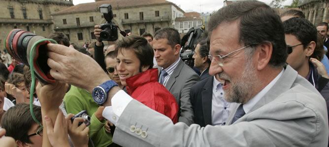 El presidente del PP se encuentra con varios jóvenes en la plaza del Obradoiro de Santiago de Compostela, momentos antes del inicio del acto popular con alcaldes de Galicia que se ha celebrado esta mañana y donde ha prometido un Gobierno &quot;serio&quot; y con &quot;co