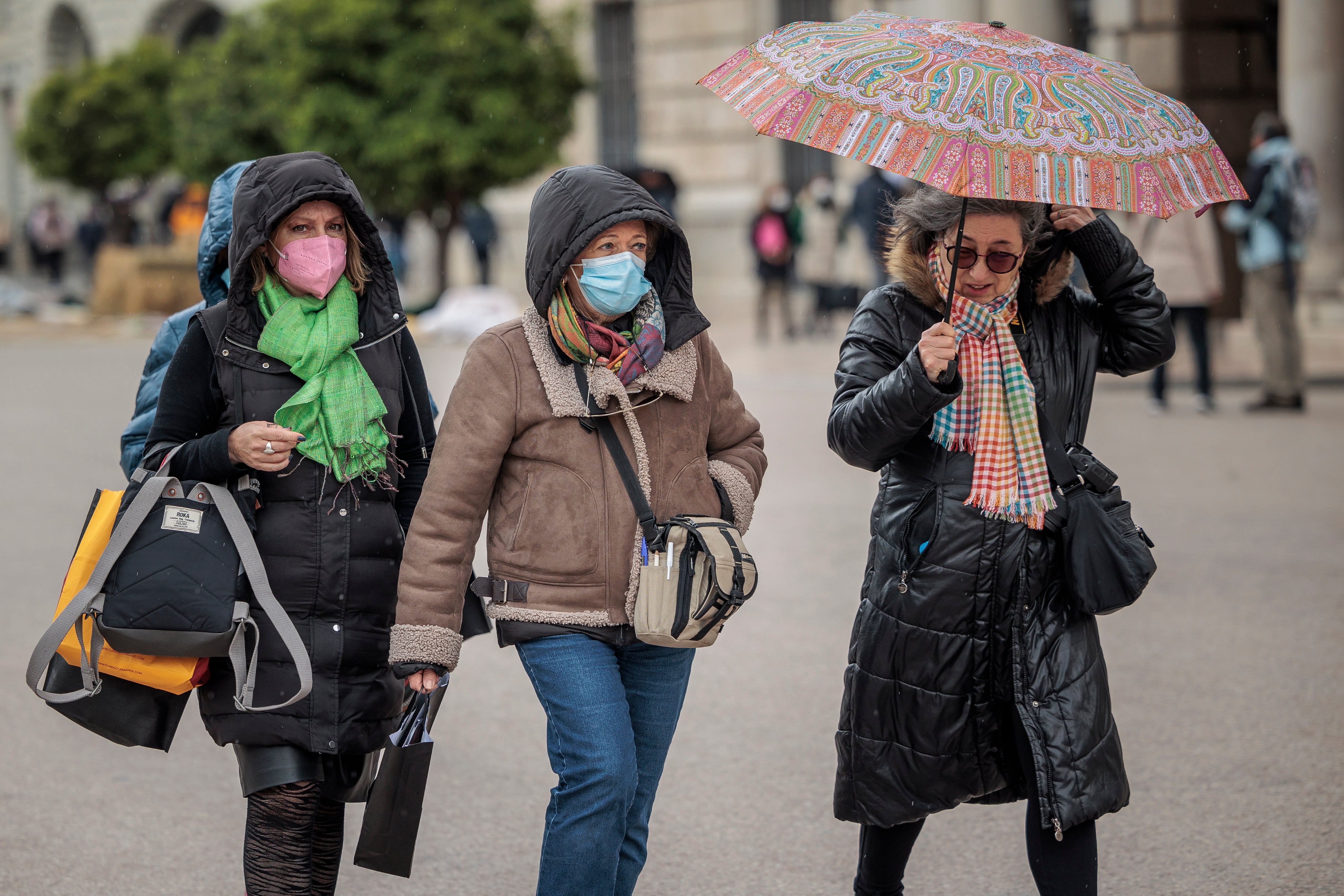 Varias personas pasean abrigadas por el centro de Valencia.