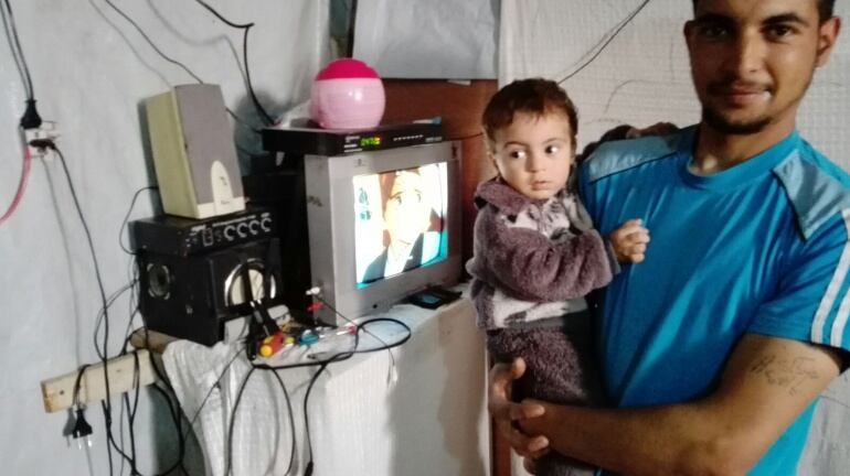 Uno de los refugiados del campamento posa con su hijo pequeño