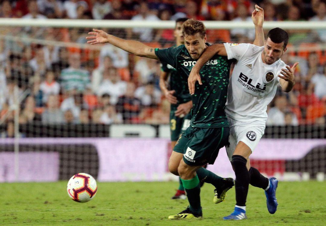 El centrocampista del Betis, Sergio Canales, lucha un balón ante el defensa del Valencia, José Gayá