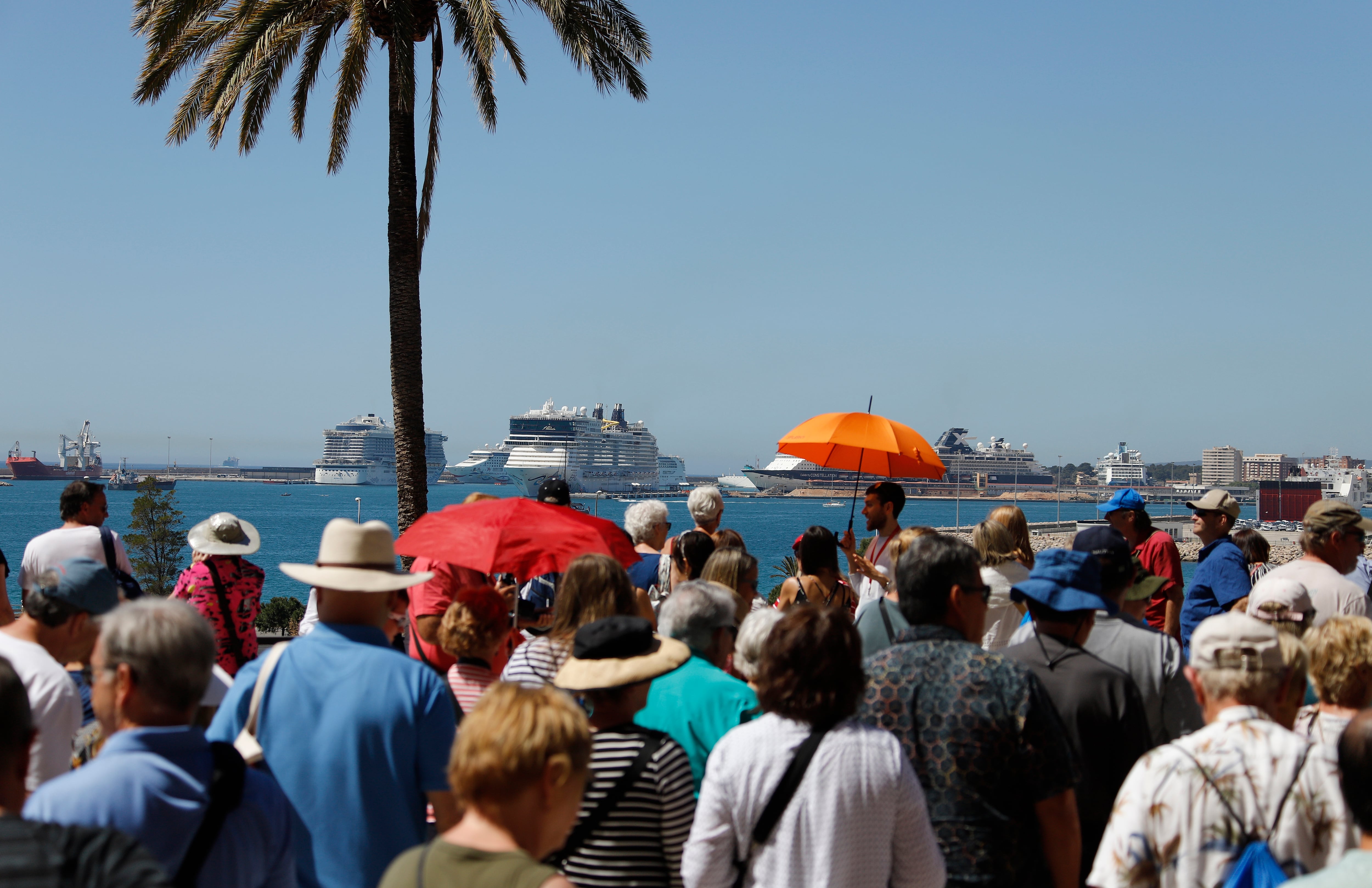 11 May 2019, Spain, Palma: Tourists take photos of cruise ships in the port of Palma de Mallorca. According to forecasts by the Balearic Islands Port Authority, around 1.75 million people will arrive in the port of Palma de Mallorca on cruise ships this year. Photo: Clara Margais/dpa (Photo by Clara Margais/picture alliance via Getty Images)