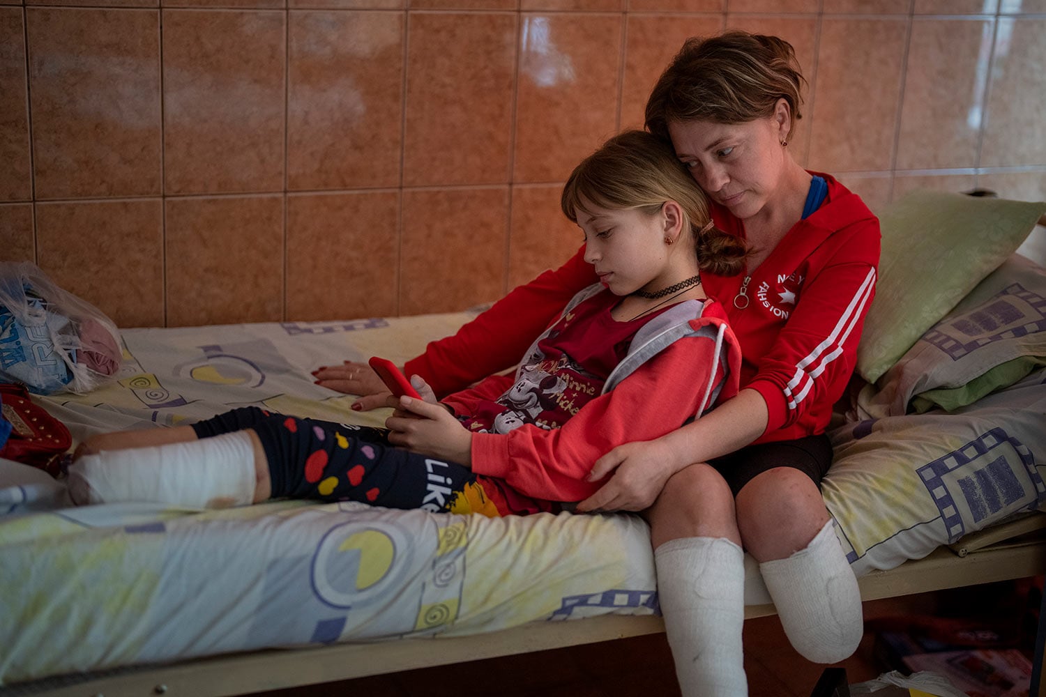 Natasha Stepanenko, 43, se sienta con su hija Yana, 11, en un hospital de Lviv, Ucrania el sábado 15 de mayo de 2022.  (AP Photo/Emilio Morenatti)