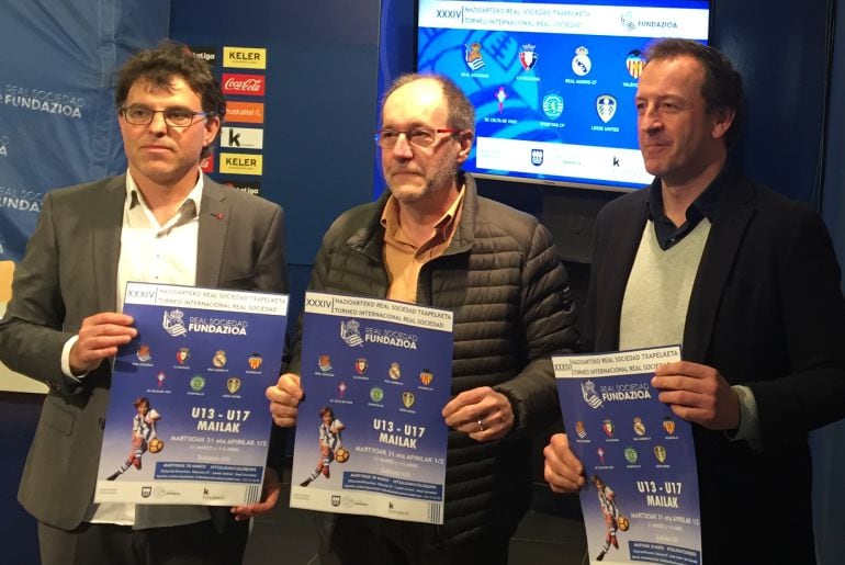 Luki Iriarte (Fútbol base Real), Joseba Ibarburu (Consejo Real) e Iñaki Iturrioz (Técnico de deportes de Diputación) posan con el cartel del Torneo