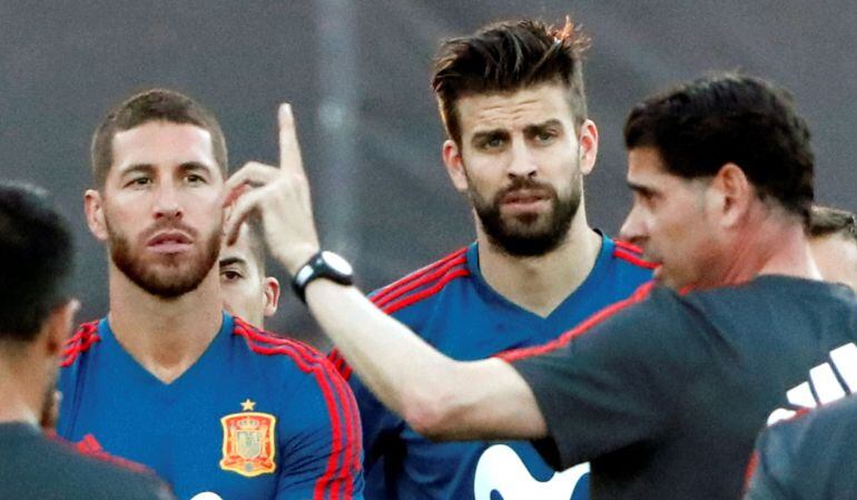 El nuevo entrenador de España Fernando Hierro (d) habla frente a Sergio Ramos (i) y Gerard Piqué (c) en su primer entrenamiento alñ frente de la selección 