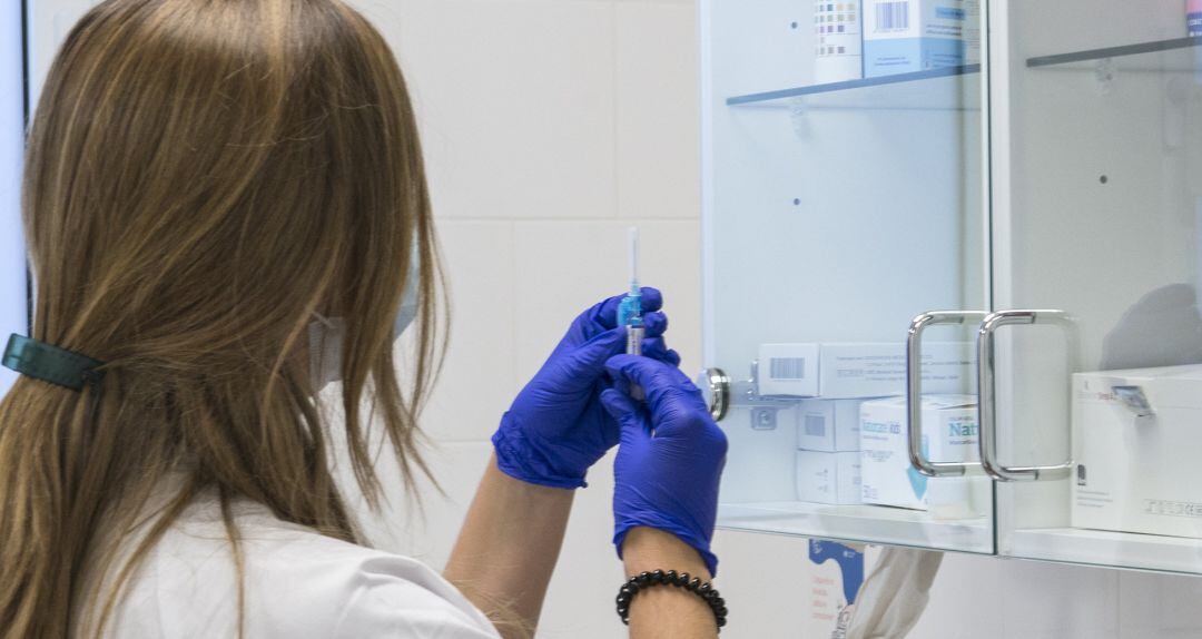 Una enfermera prepara una vacuna de la gripe.