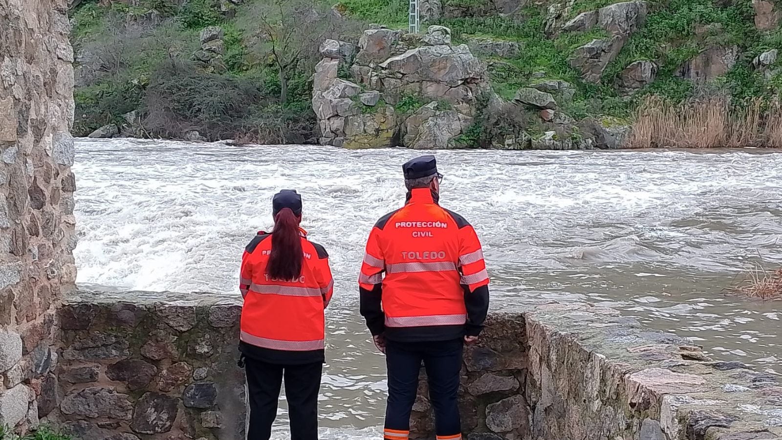 Imagen de archivo de dos voluntarios de Protección Civil Toledo monitorizando el aumento de caudal del río Tajo