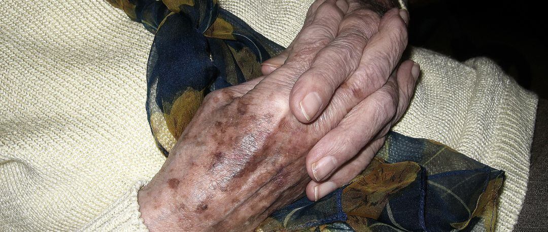 Una anciana entrelaza sus manos