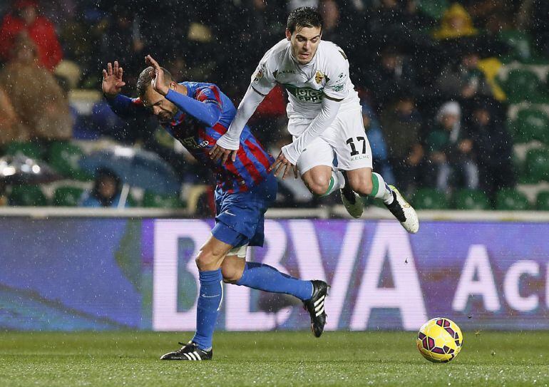 GRA328. ELCHE (ALICANTE), 18/01/2015.- El centrocampista del Elche, Victor Rodriguez (d), cae ante la entrada del defensa del Levante, Juanfran, durante el encuentro correspondiente a la decimonovena jornada de primera división, que han disputado esta noche en el estadio Martinez Valero de Elche. EFE / Manuel Lorenzo.