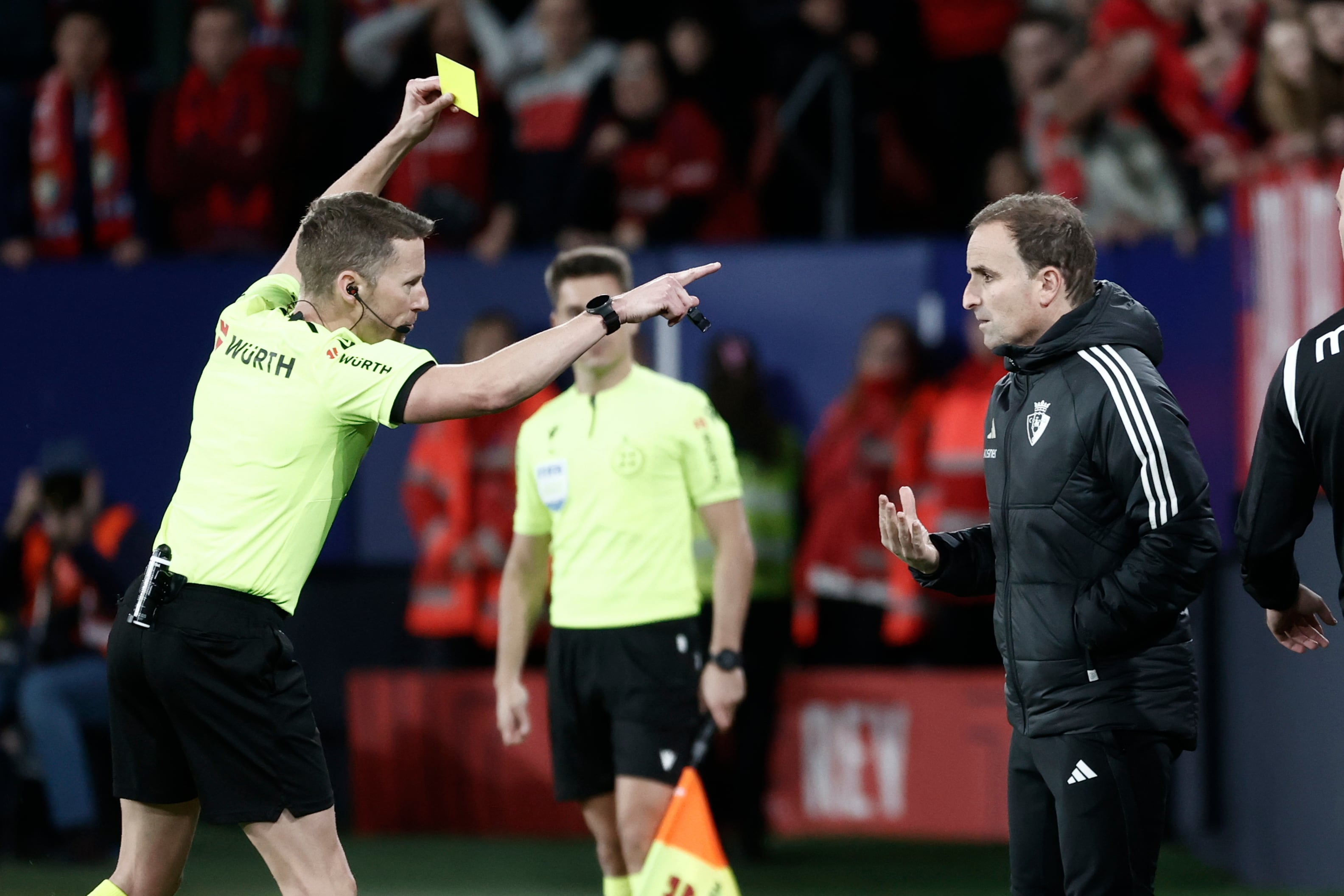 El árbitro Hernández Hernández muestra la tarjeta amarilla al entrenador de Osasuna, Jagoba Arrasate, por protestar durante el partido de los octavos de final de la Copa del Rey de fútbol que entre Osasuna y Real Sociedad este miércoles en el estadio de El Sadar, en Pamplona