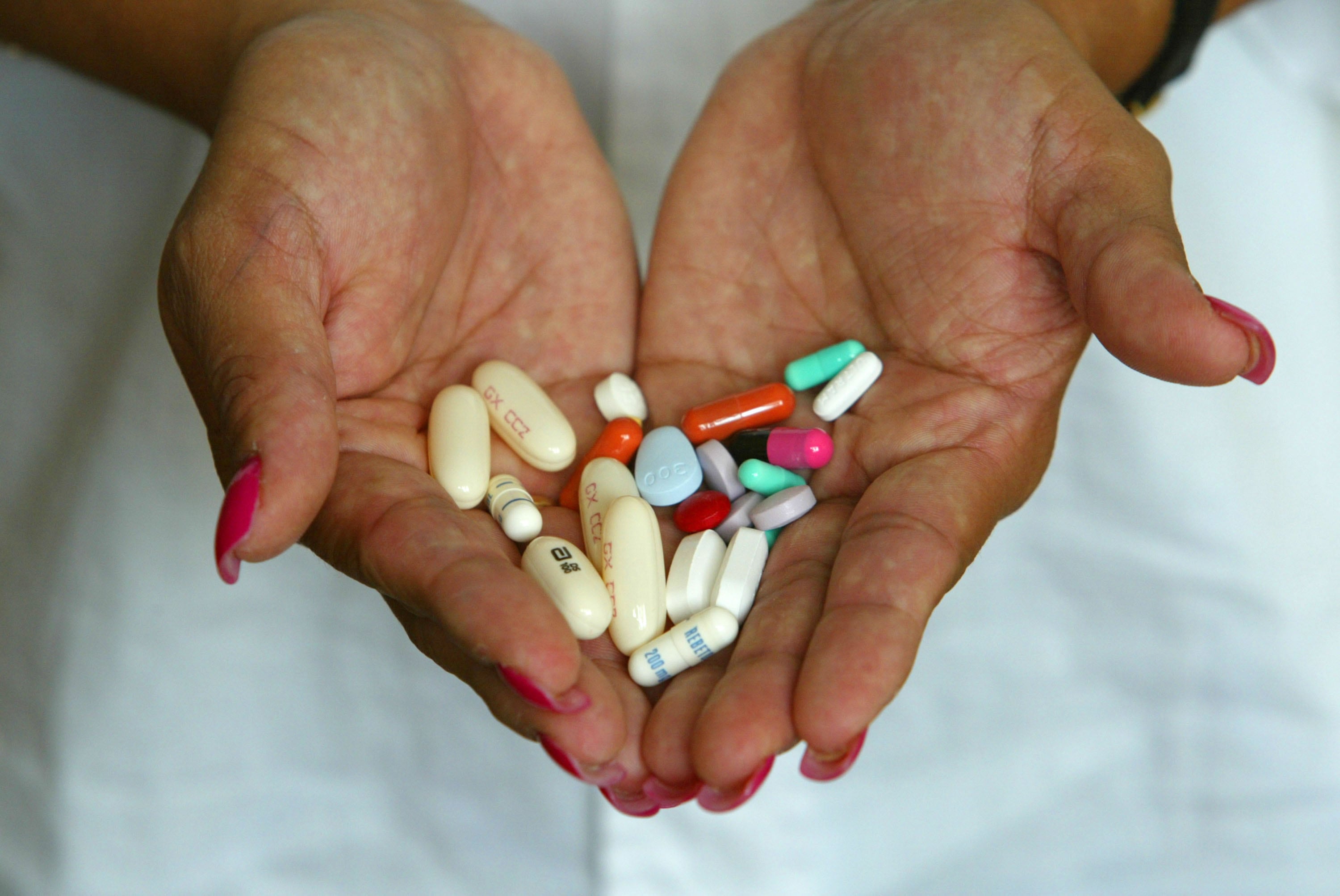 Una mujer sostiene varias pastillas.