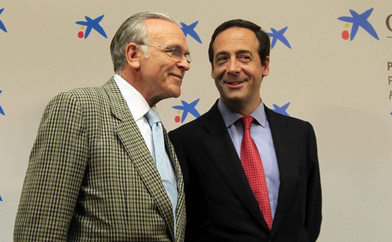 El consejero delegado de CaixaBank, Gonzalo Gortázar (d), conversa con su antecesor en el cargo a Juan María Nin, momentos antes de la rueda de prensa de la entidad, el pasado mes de julio. EFE/Archivo