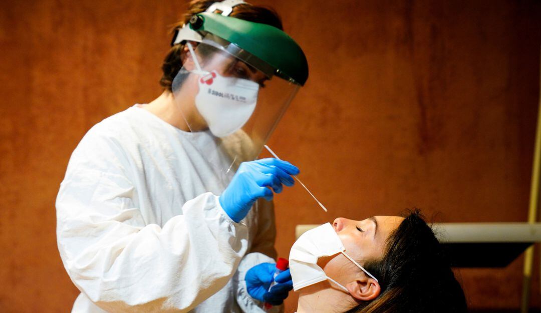 A medical staff member administers a PCR test