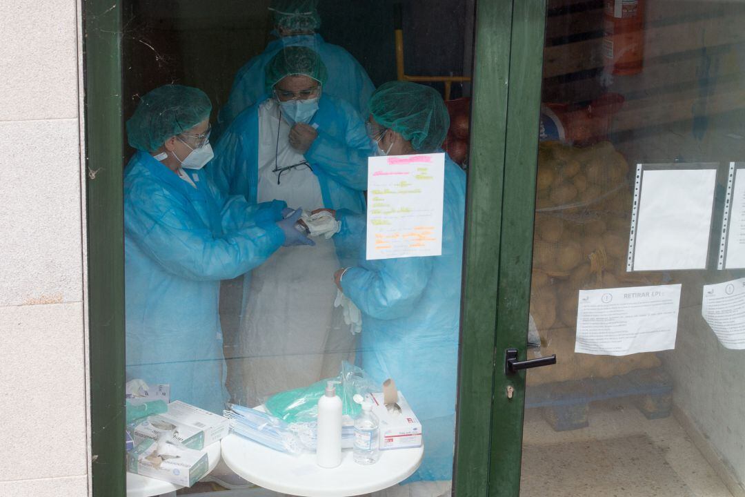 Tres mujeres en la puerta de la residencia una ancianos.