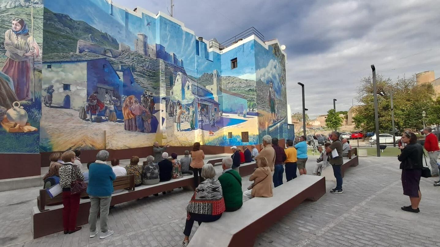 Turistas visitando el mural de la plaza Nueva