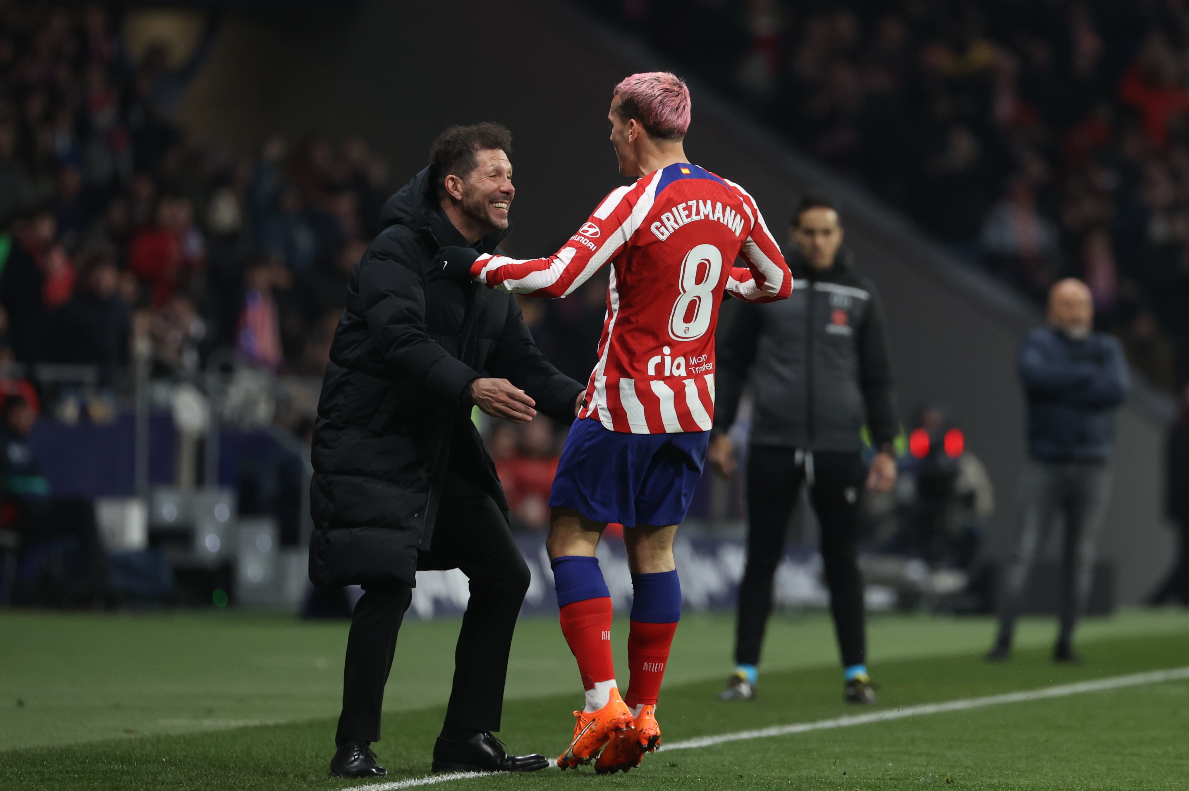 El delantero del Atlético de Madrid Antoine Griezmann celebra con su entrenador, Diego Pablo Simeone, tras marcar el tercer gol durante el partido de Liga contra el Sevilla FC.