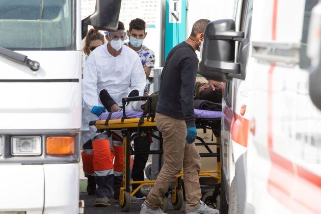 Un inmigrante del muelle de Arguineguín (Gran Canaria) es trasladado en ambulancia este lunes.