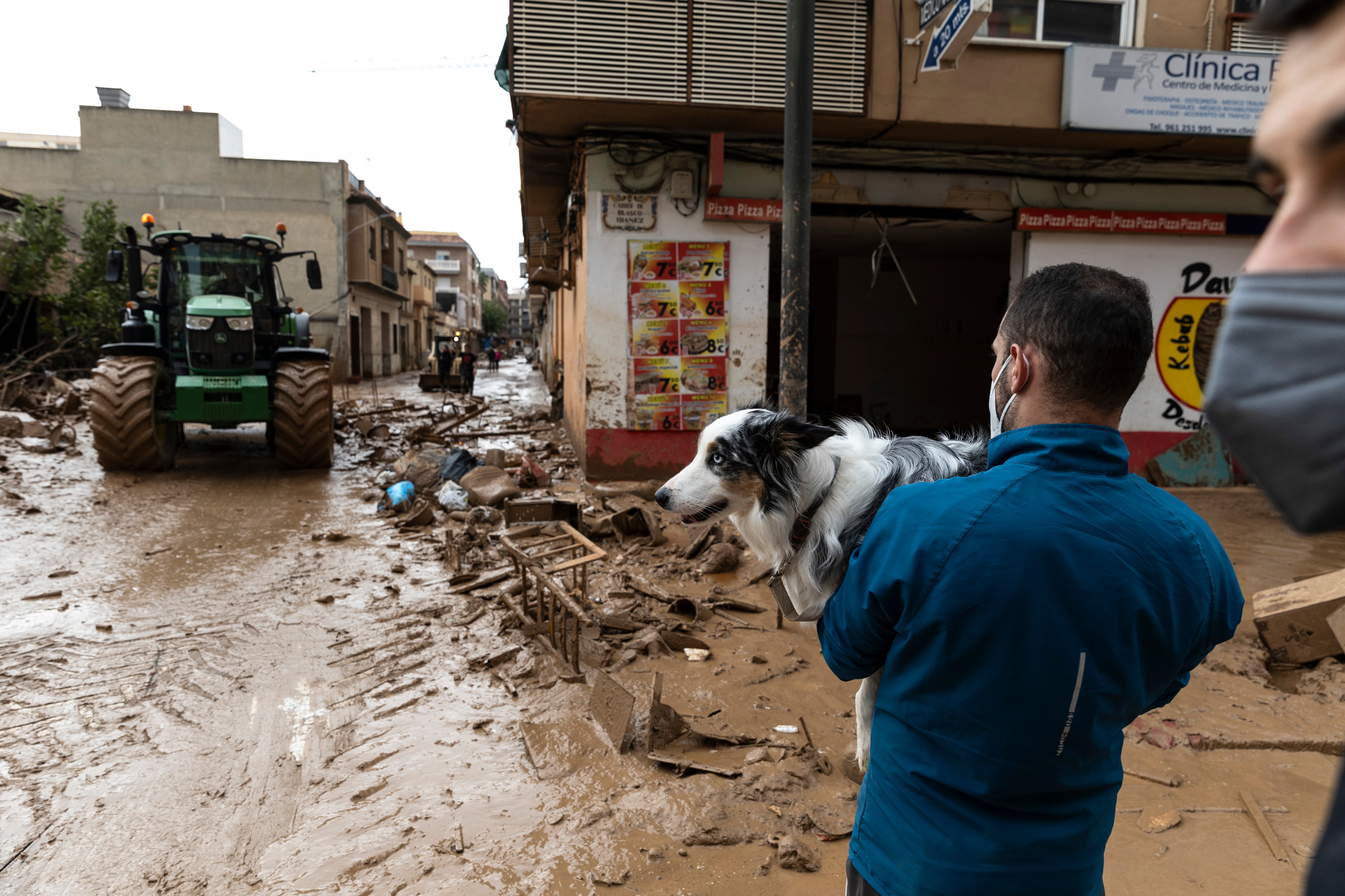 VALENCIA, SPAIN - NOVEMBER 03: A man carries his dog on his arms as he crosses mud after heavy rain and flooding hit large parts of the country on November 03, 2024 in the Massanassa municipality, in Valencia, Spain. By Friday, Spanish authorities confirmed that at least 200 people had died, mostly in the Valencia region, amid the flooding that swept eastern and southern parts of the country starting on Tuesday. The intense rainfall event is known as a &quot;cold drop&quot; or DANA weather system. (Photo by Pablo Blazquez Dominguez/Getty Images)