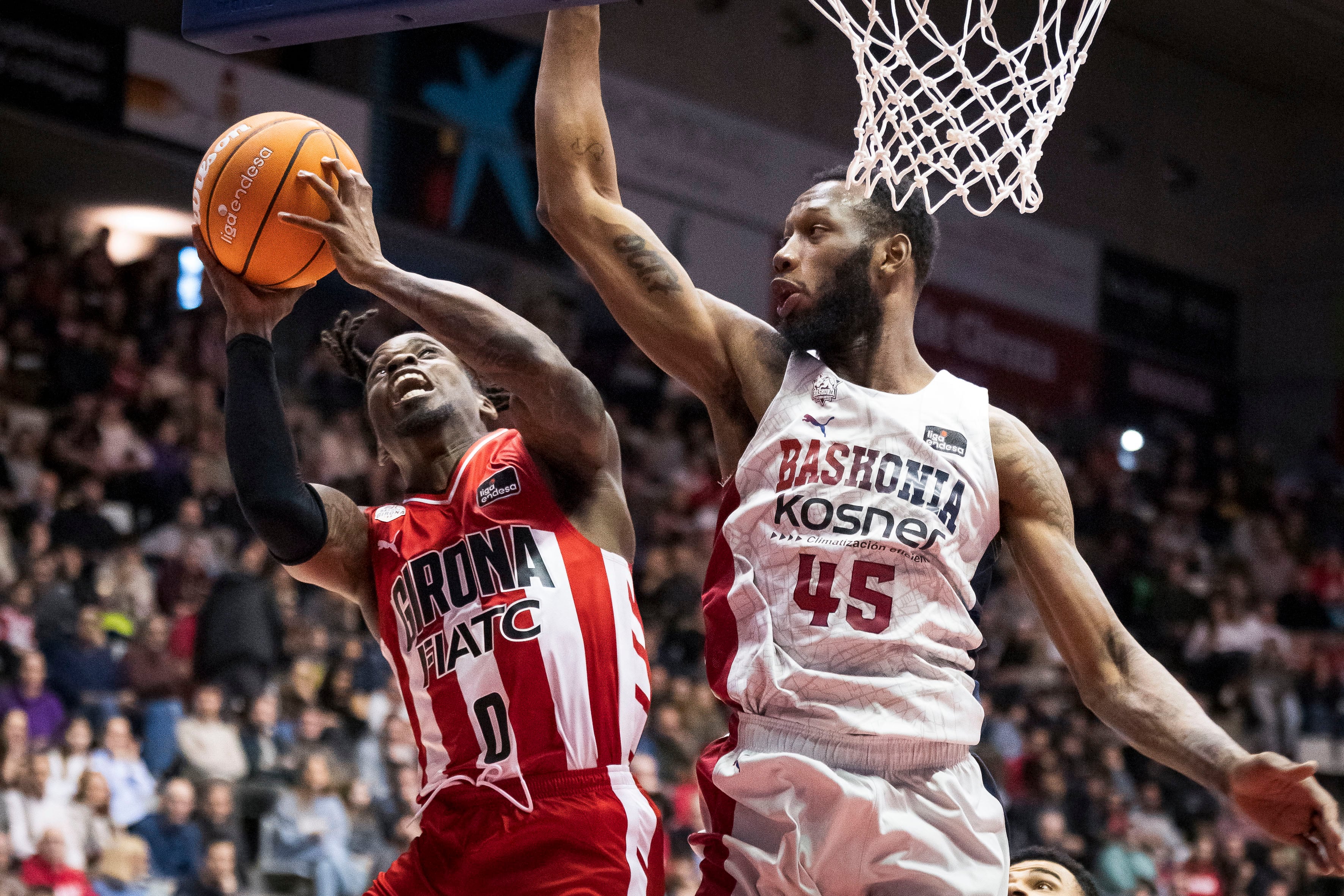 GIRONA, 12/01/2025. - El base nigeriano del Girona Ike Iroegbu (i) lanza a canasta ante el pívot estadounidense del Baskonia, Donta Hall, durante el partido de Liga Endesa de baloncesto que se disputa este domingo en el pabellón de Fontajau. EFE/David Borrat.
