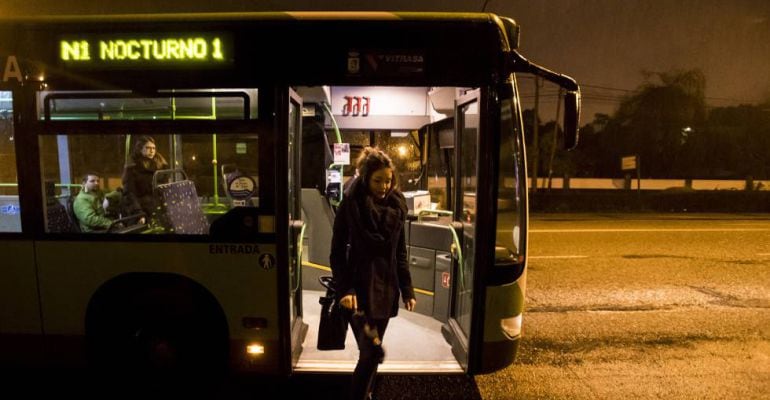 Una mujer se baja de un autobús nocturno