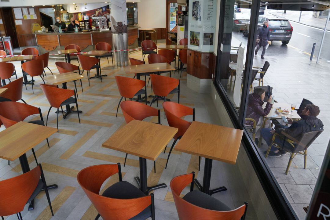 Dos personas toman el aperitivo en una mesa de la terraza de un bar, en Santiago de Compostela, A Coruña (Galicia), a 22 de octubre de 2020. 