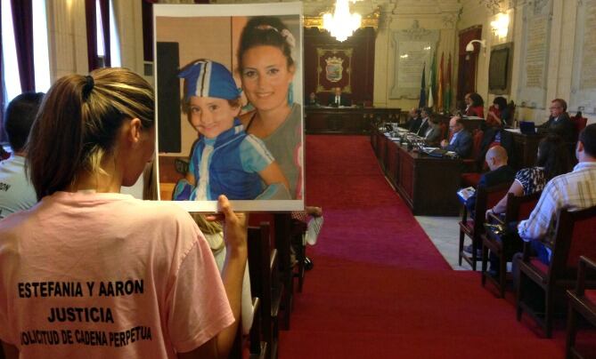 Vecina de la barriada de la Luz con una foto de Estefanía y Aarón en el pleno municipal